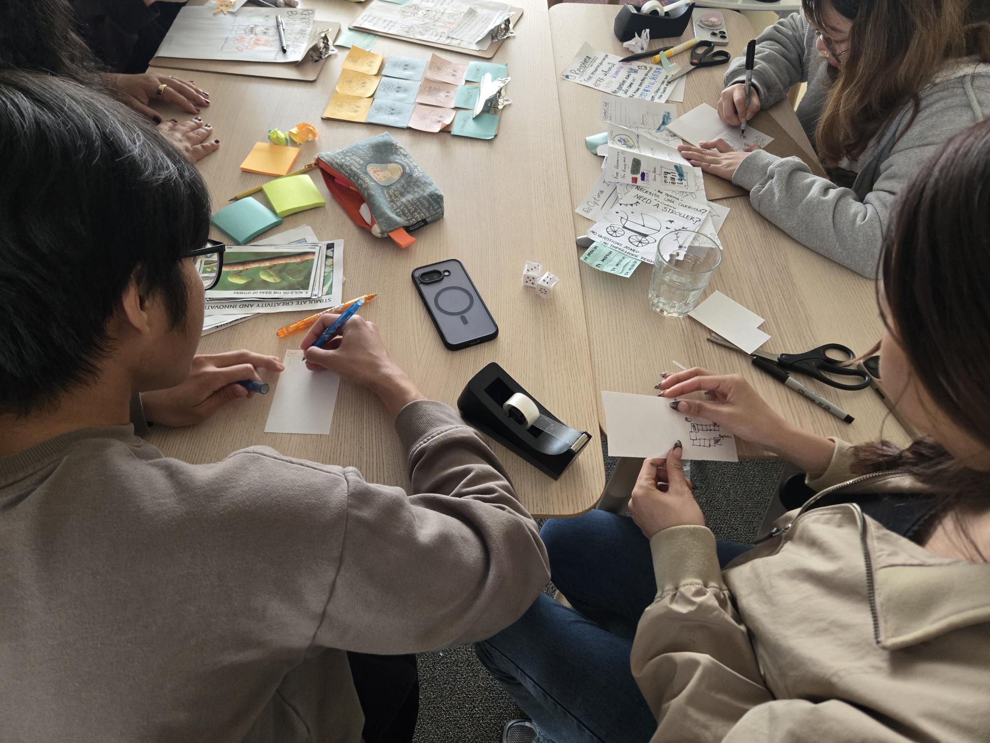 Aerial view of Accelerate scholars making prototypes out of paper at a table