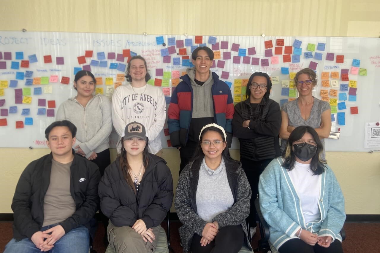 Accelerate scholars cohort 2023 pose in front of an idea board covered in sticky notes
